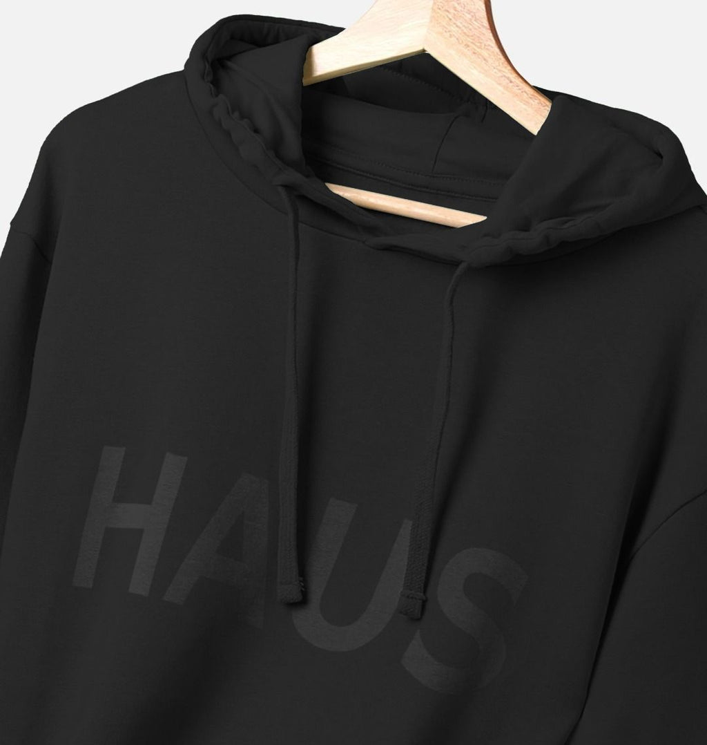 Black Haus Collection Hoodie close-up of HAUS logo on hanger